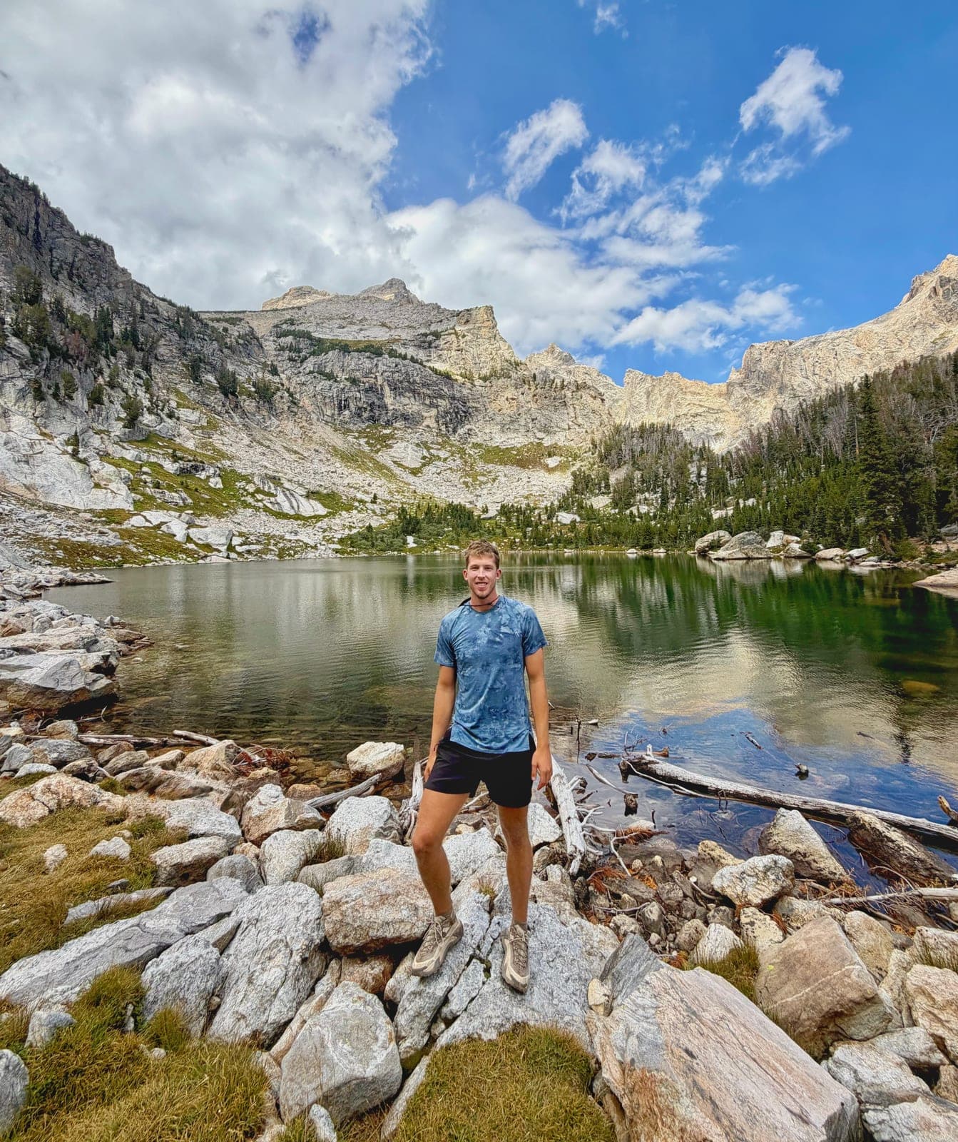 Owen standing on granite boulders at the edge of Amphitheater Lake, with peaks behind