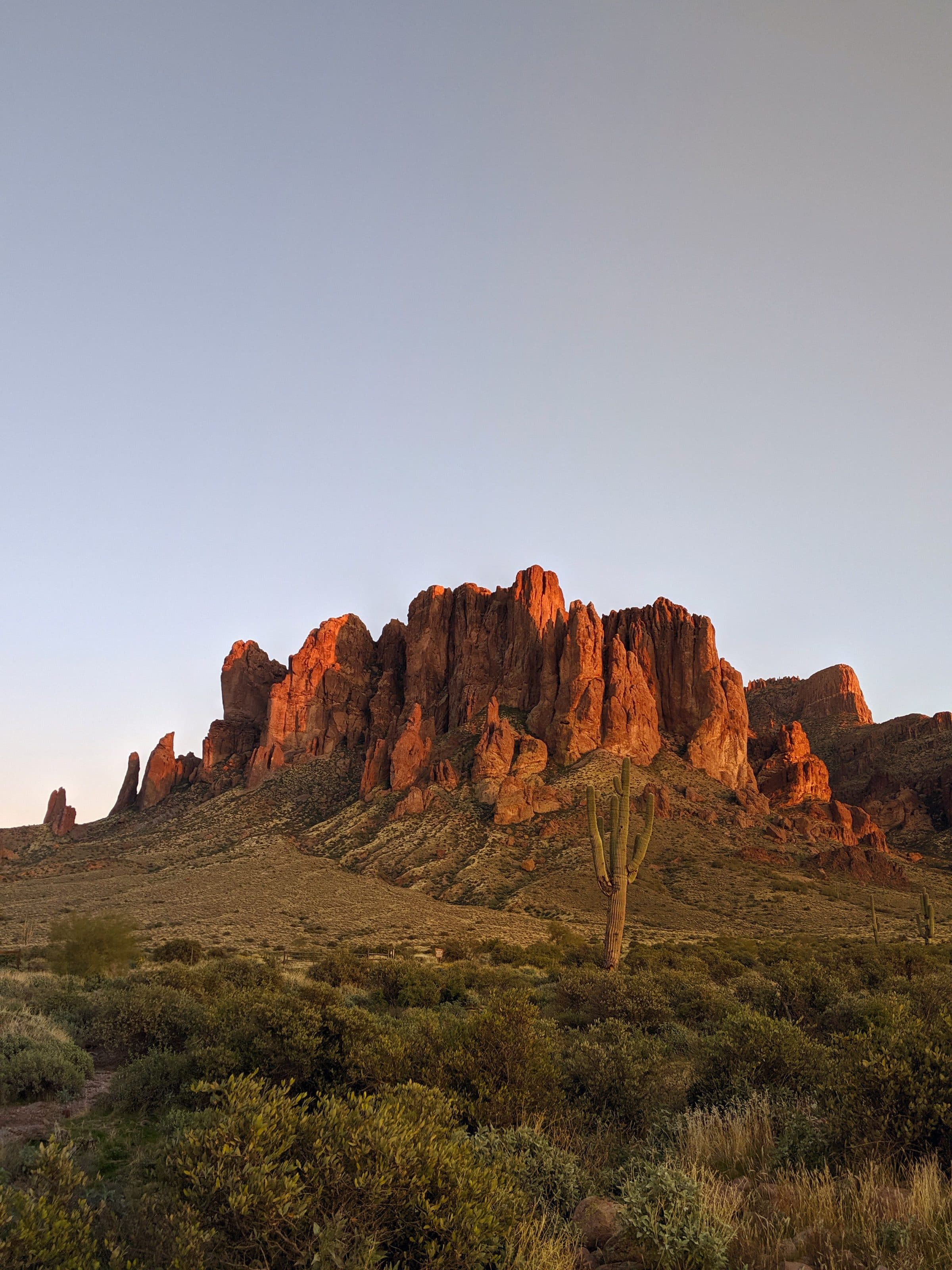 The Superstition Mountains lit red at sunset above the desert at Lost Dutchman State Park, where Siphon Draw starts